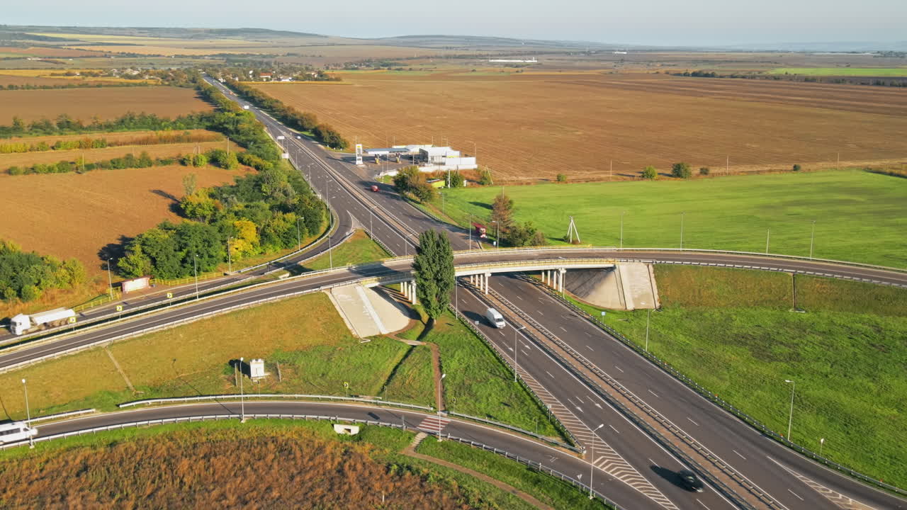 Aerial drone view of a road junction with moving cars and nature, greenery, fields, village, Moldova