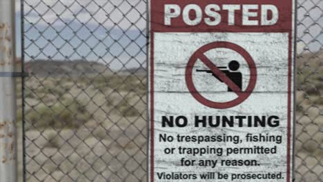 high quality 3d cgi render of a chainlink fence at a high security installation in a desert scene, with a no hunting no trespassing sign