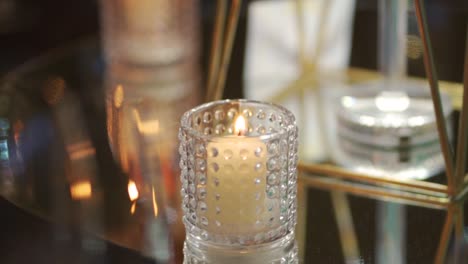 burning candle in a glass jar on a wedding table