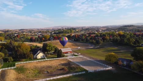 Drohnenansicht-Eines-Wunderschönen-Heißluftballons,-Der-Auf-Einem-Feld-Landet