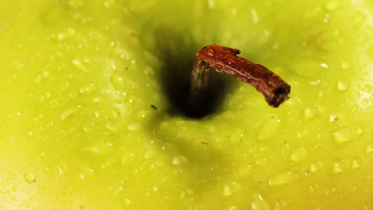 toma detallada de gotas de agua y tallo roto en una manzana verde