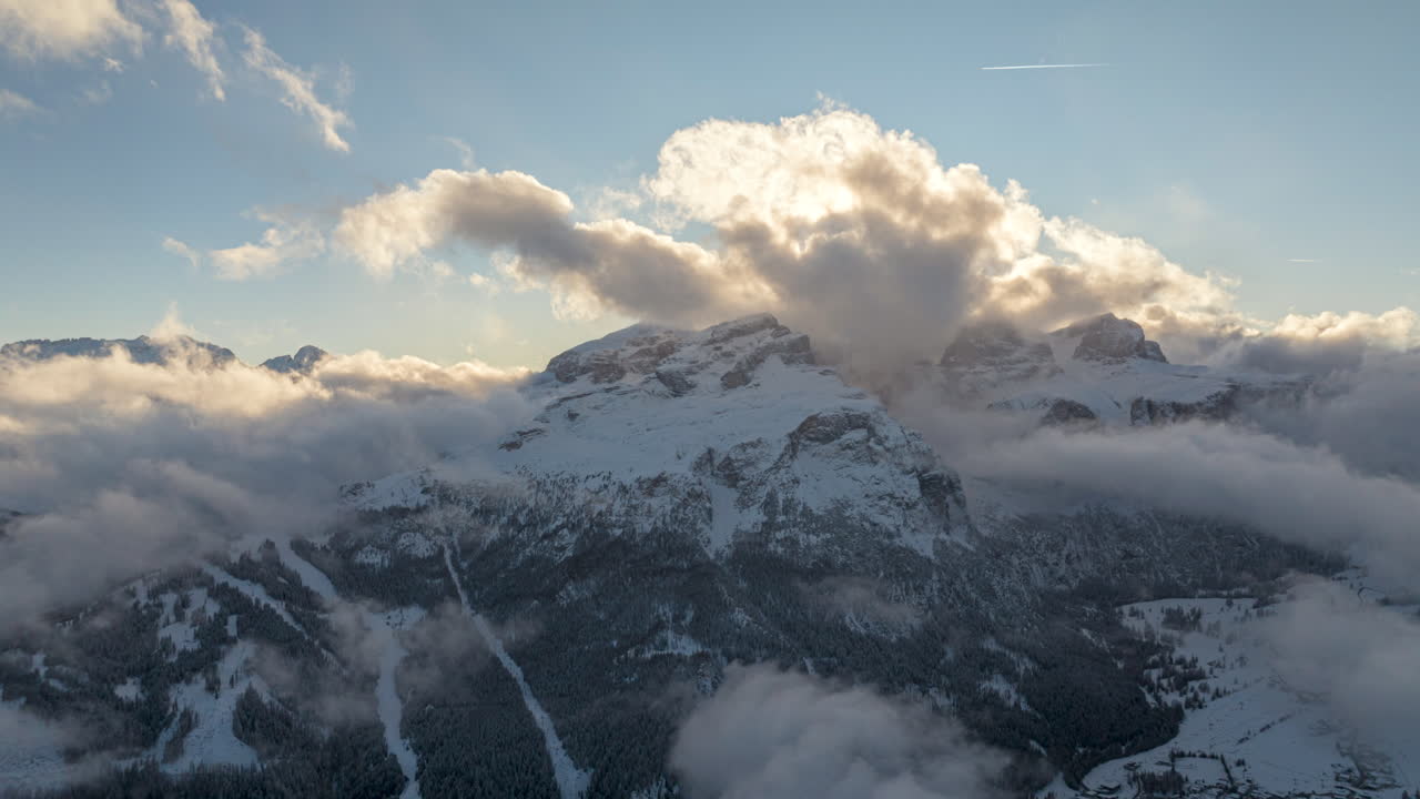 Aerial hyperlapse timelapse of Dolomites Mountains in winter season. Moving clouds at sunset