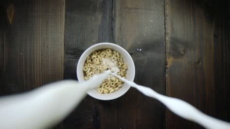 vista única de la leche que se vierte en un tazón de cereal