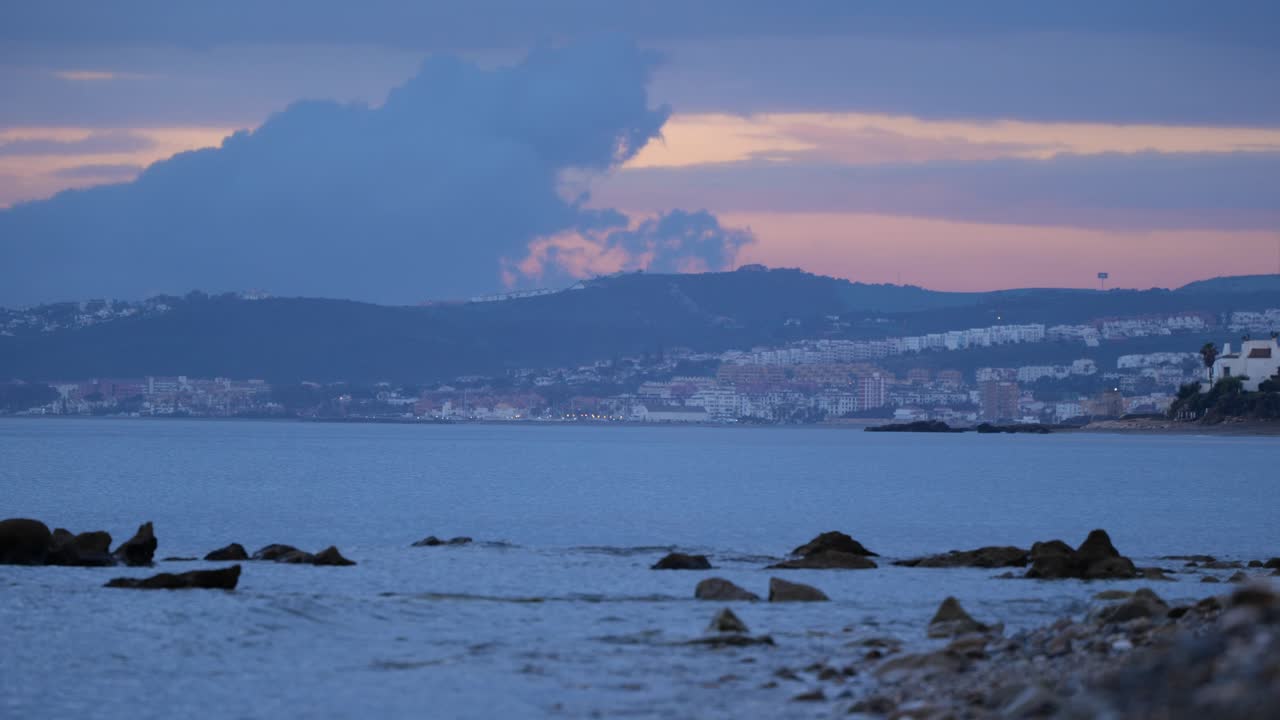 vista del paisaje natural de la hermosa playa y el mar con pequeñas olas y montañas en el fondo