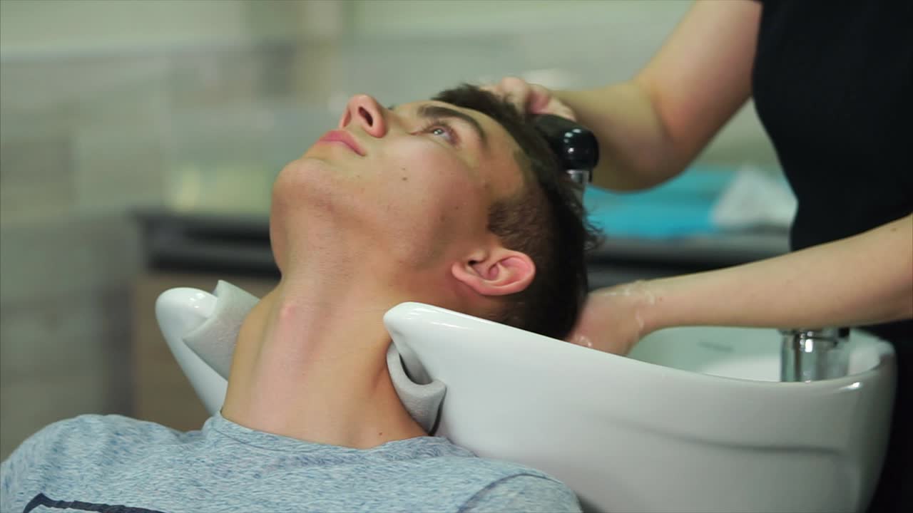 Teenager getting a haircut and hair wash at a salon