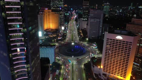 night time illuminated jakarta city center traffic street circle fountain aerial panorama 4k indonesia