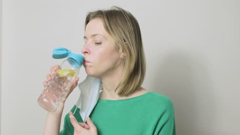 Una-Mujer-Tiene-Que-Quitarse-La-Máscara-De-Ppe-Antes-De-Poder-Beber-De-Su-Botella-De-Agua