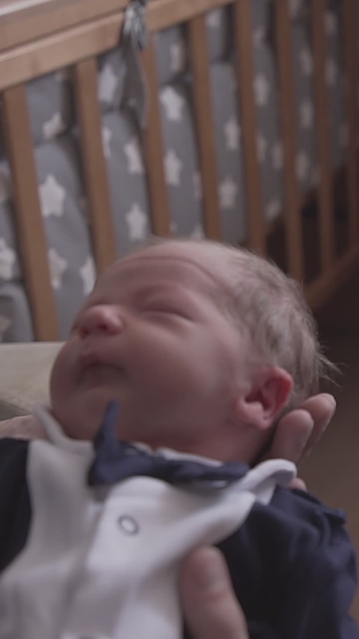 pretty little blond girl kisses junior brother in funny tuxedo lying in father arms at children room closeup