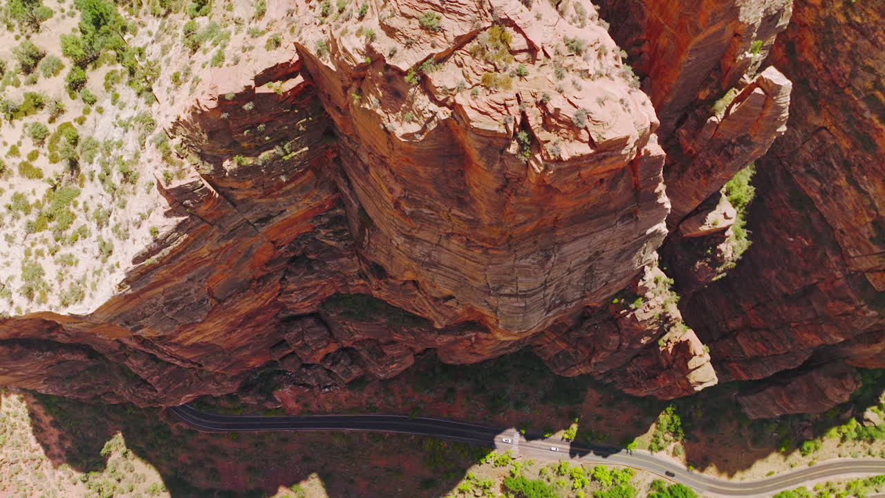 Amazing red rocks created by air erosion. Descending along the splendid rocks and motorways going at their foot. Top view.