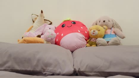 Cute-stuffed-toys-sitting-on-pillows-in-the-bedroom