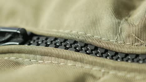 close up of a zipper on a green fabric