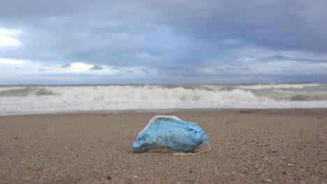 dirty medical mask on sandy seashore