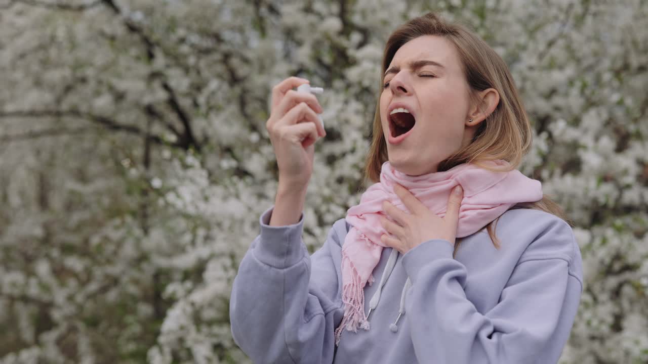 Woman with Sore Throat Using Throat Spray Outdoors