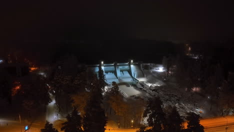 panoramic drone shot orbiting the illuminated imatra dam, winter night in finland