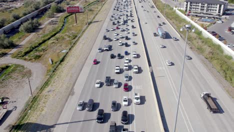 toma aérea inclinada hacia arriba que revela automóviles circulando en el tráfico en la autopista interestatal en utah