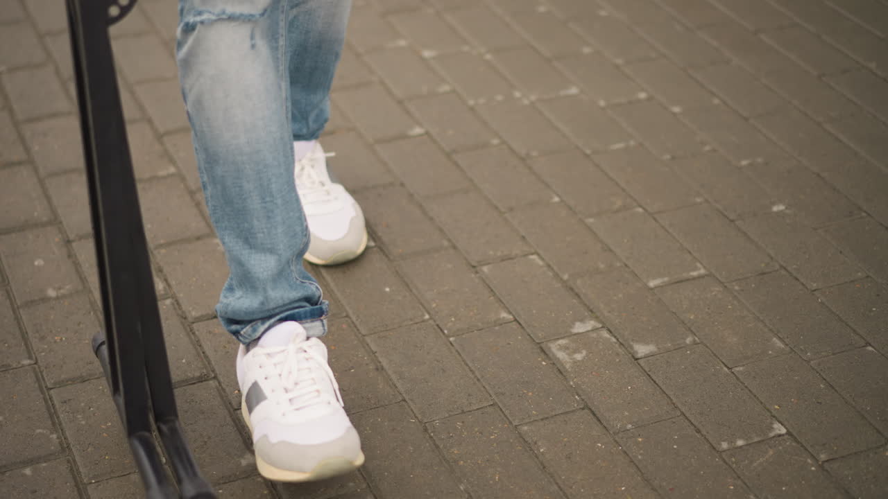 Performans sonrası sessiz bir an. Spor ayakkabılar duraksarken sahne görevlisi uzaklaşıyor. Eskimiş kot pantolon ve kararlı adımlar, etkinliğin sonunu işaret ediyor. Ayakkabı ve ekipmanın yakın çekimi, gösterinin sessiz sona erişini yakalıyor.