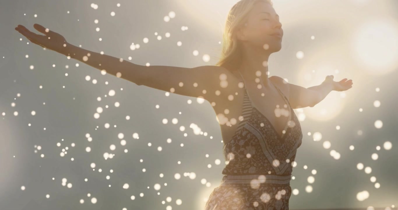 Mid-adult woman opening arms at sunrise for travel, embracing sunlight with flares over form