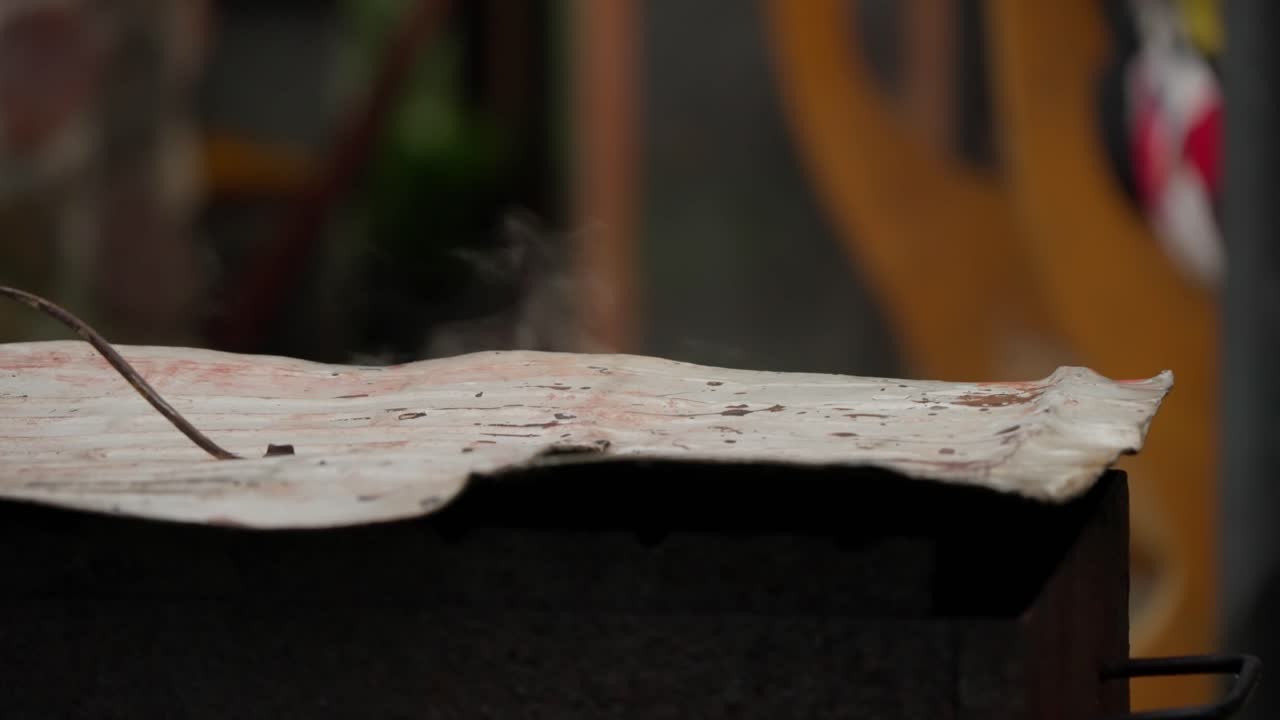 Fumo che sale da sotto un coperchio di metallo ondulato
