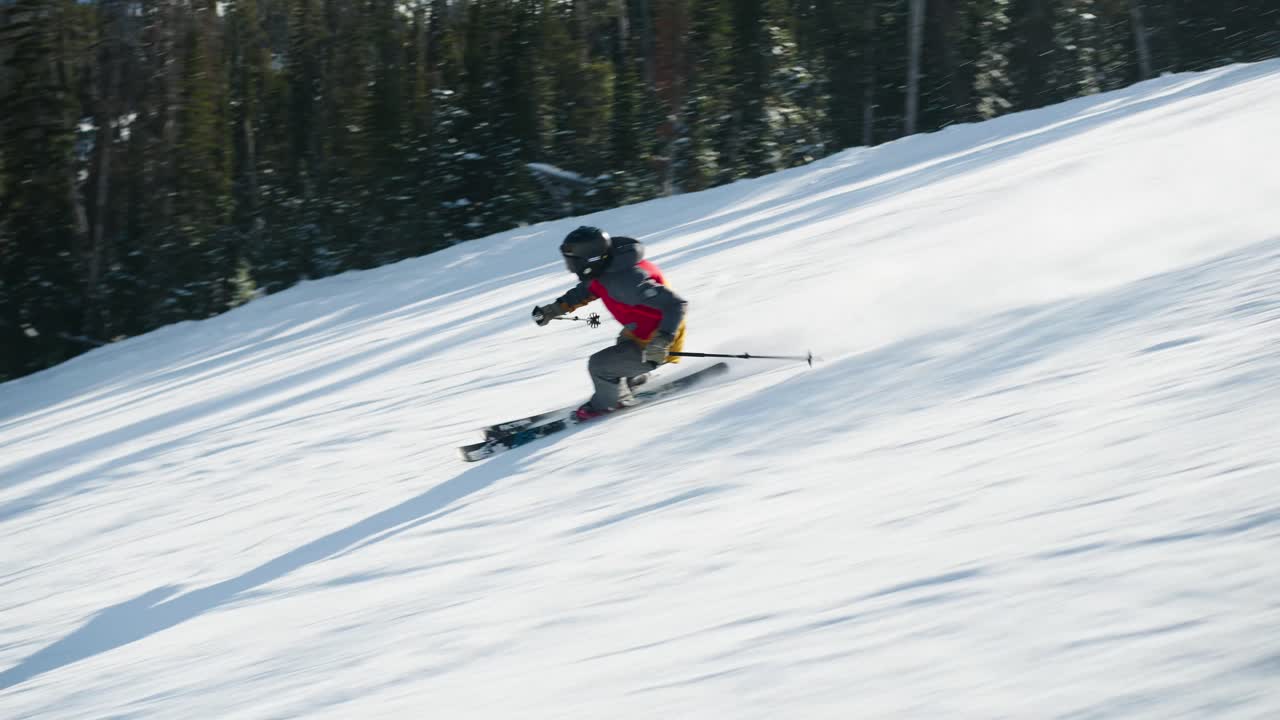 A skier on a nice day skiing fast on a groomed run in Big Sky Montana