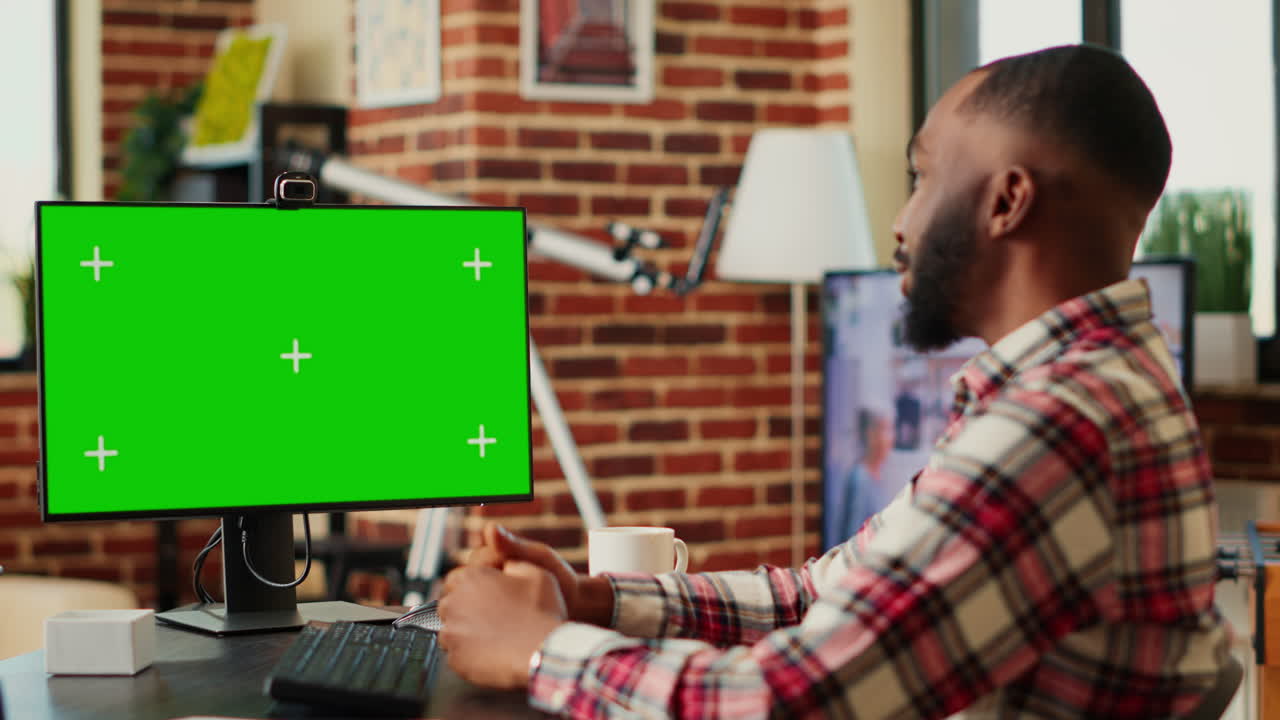Uomo che lavora al computer con lo schermo verde