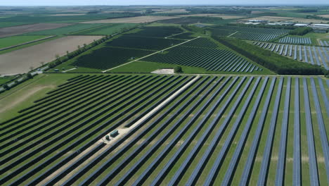 High-Establishing-Panning-Drone-Shot-of-Fields-of-Solar-Panels-on-Solar-Farm-on-Sunny-Day