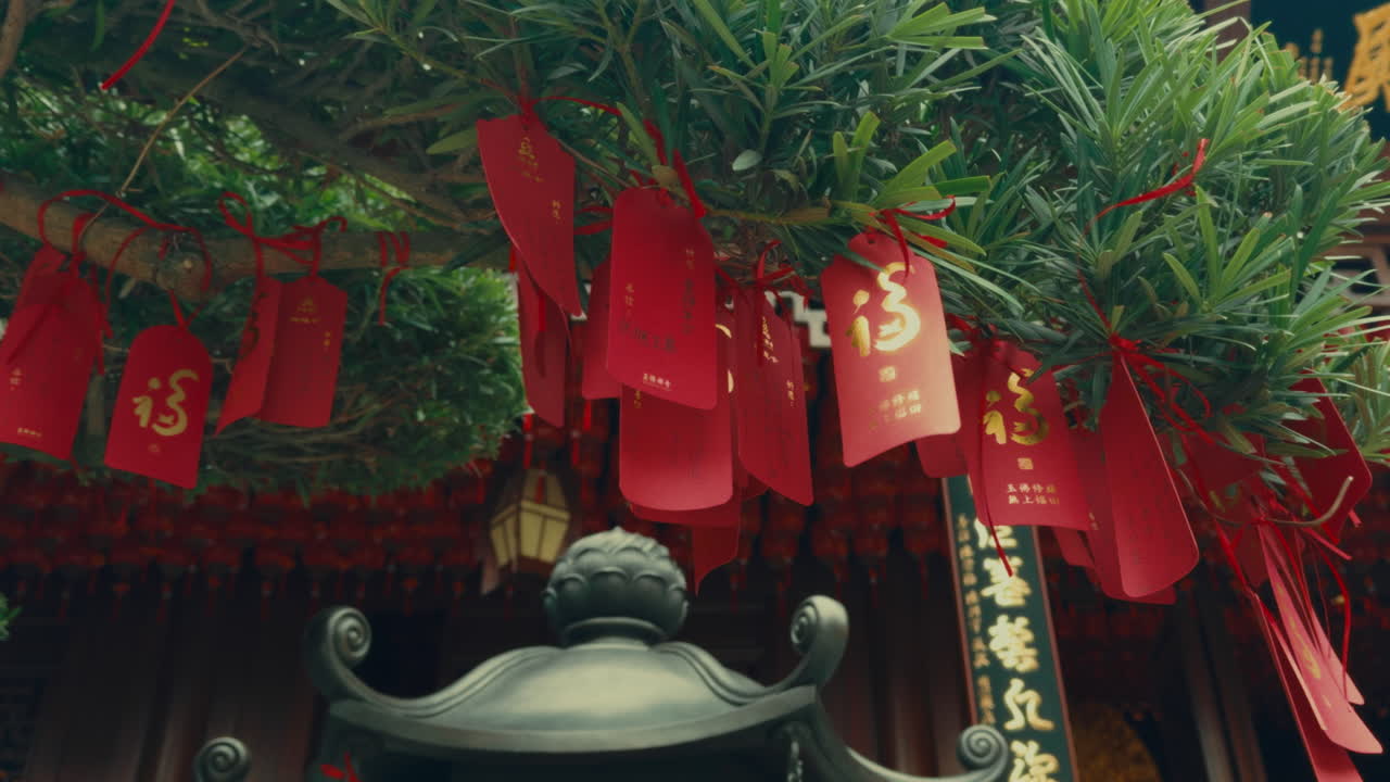 A collection of red prayer tags hanging from a tree in Wuzhen, China, symbolizing wishes.