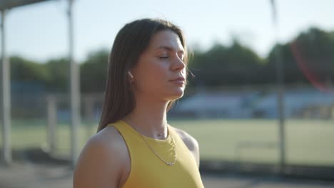 atleta femenina corriendo en pista al aire libre con ropa deportiva