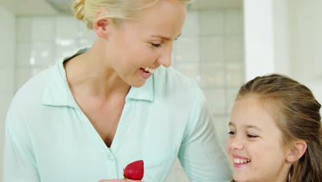 Hija-Sonriente-Dándole-Fresa-A-Su-Madre