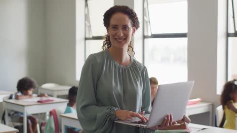 Video-De-Una-Feliz-Maestra-Caucásica-Usando-Una-Computadora-Portátil-En-La-Escuela-Durante-Las-Lecciones