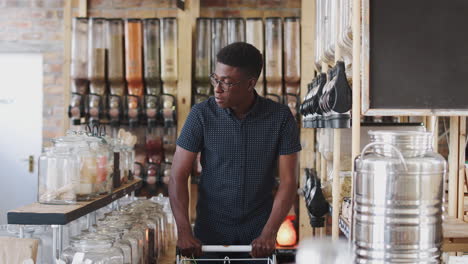 joven mirando productos en una tienda de comestibles sostenible sin plástico