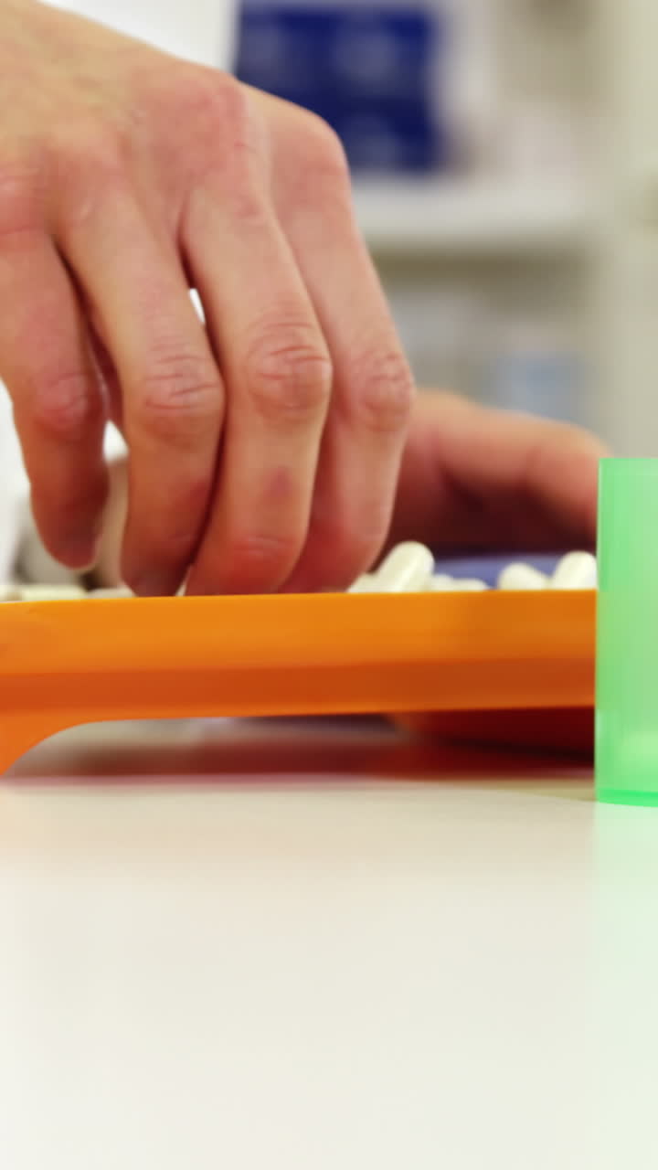 farmacéutico poniendo píldoras en el recipiente en la farmacia