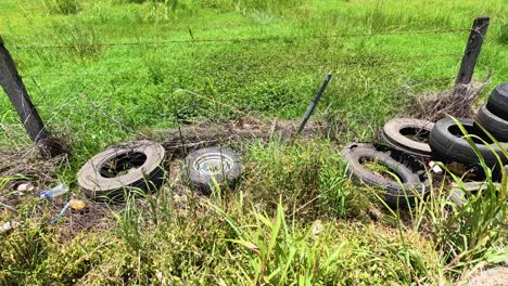 old tires littered along a grassy roadside