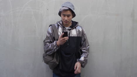Porträt-Eines-Jungen-Asiatischen-Studenten,-Der-Mit-Der-Voice-Memo-App-Für-Künstliche-Intelligenz-Auf-Dem-Smartphone-Spricht-Und-Stilvolle-Mode-In-Zeitlupe-Trägt