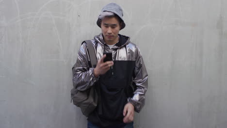 portrait young asian man student talking on smartphone using artificial intelligence voice memo app wearing stylish fashion slow motion