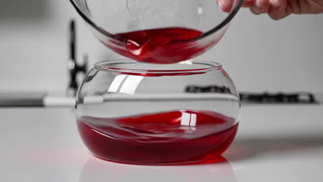 red liquid pouring into glass bowl