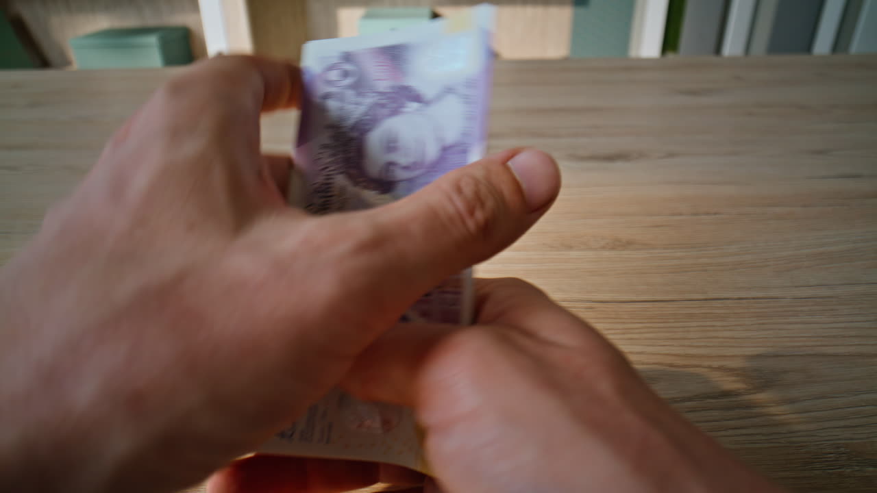 Man hands counting pounds for financial transaction at office desk closeup