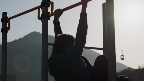 young man performing pull-ups outdoors