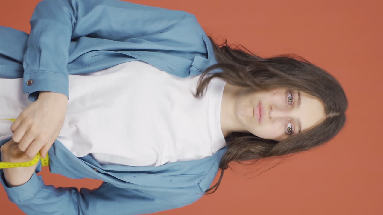 자신의 체중에 불만족한 젊은 여성의 수직 비디오.