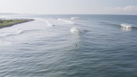 Aéreo:-Surfistas-Relajándose-En-Tablas-De-Surf-Detrás-De-Olas-Perfectamente-Rompientes,-Surf-Remoto-Mexicano