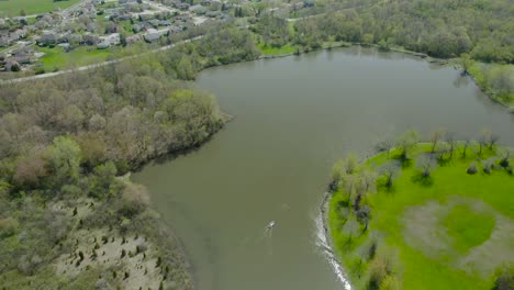 Aerial-vertical-reveal-of-a-suburban-area-with-houses-near-a-small-lake-in-western-suburbs-of-Chicago,-Illinois