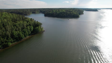 Fast-motorboat-in-the-Stockholm-archipelago-river-delta,-summer-aerial