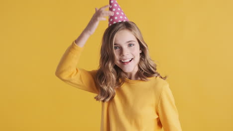 Teenage-Caucasian-girl-wearing-a-party-hat-and-dancing.