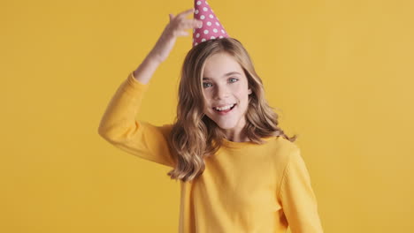 teenage caucasian girl wearing a party hat and dancing.