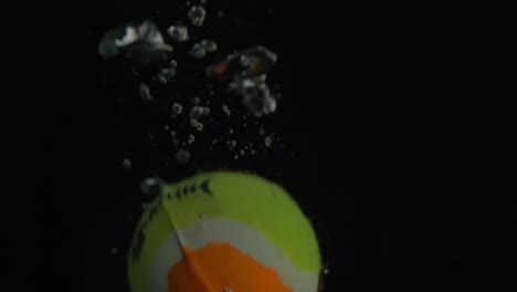 Nahaufnahme-Des-Fallenden-Kleinen-Balls-Ins-Wasser-Mit-Blasen-Mit-Schwarzem-Hintergrund
