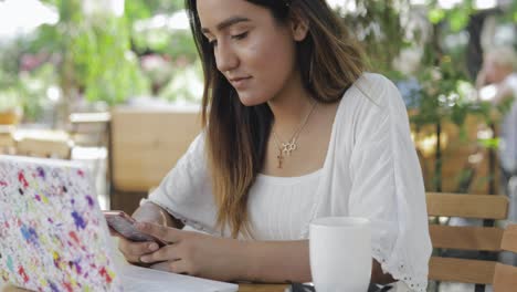 mujer joven leyendo su teléfono móvil