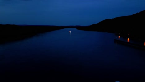 hydroelectric dam on the river at night - aerial pullback