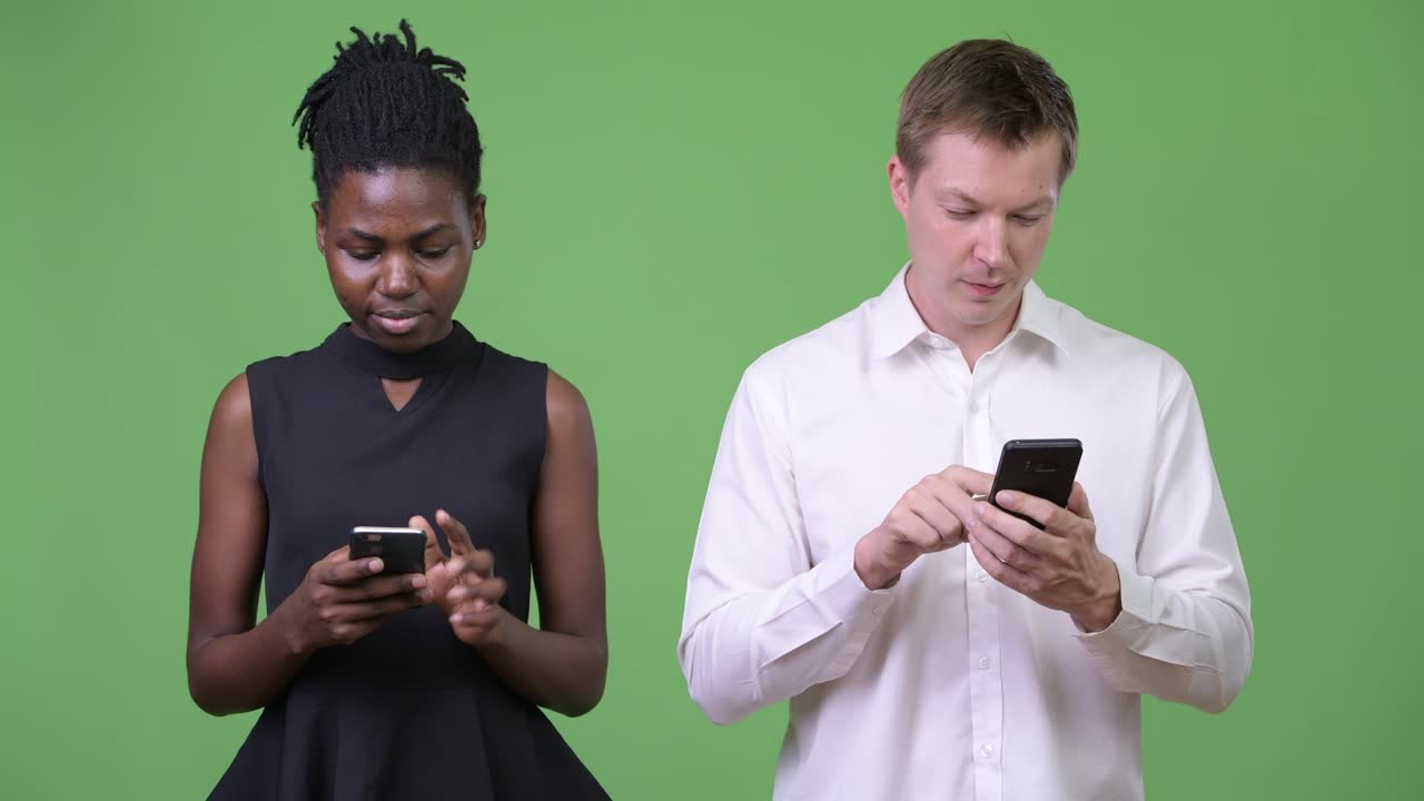 Two young multi-ethnic business couple using phone together
