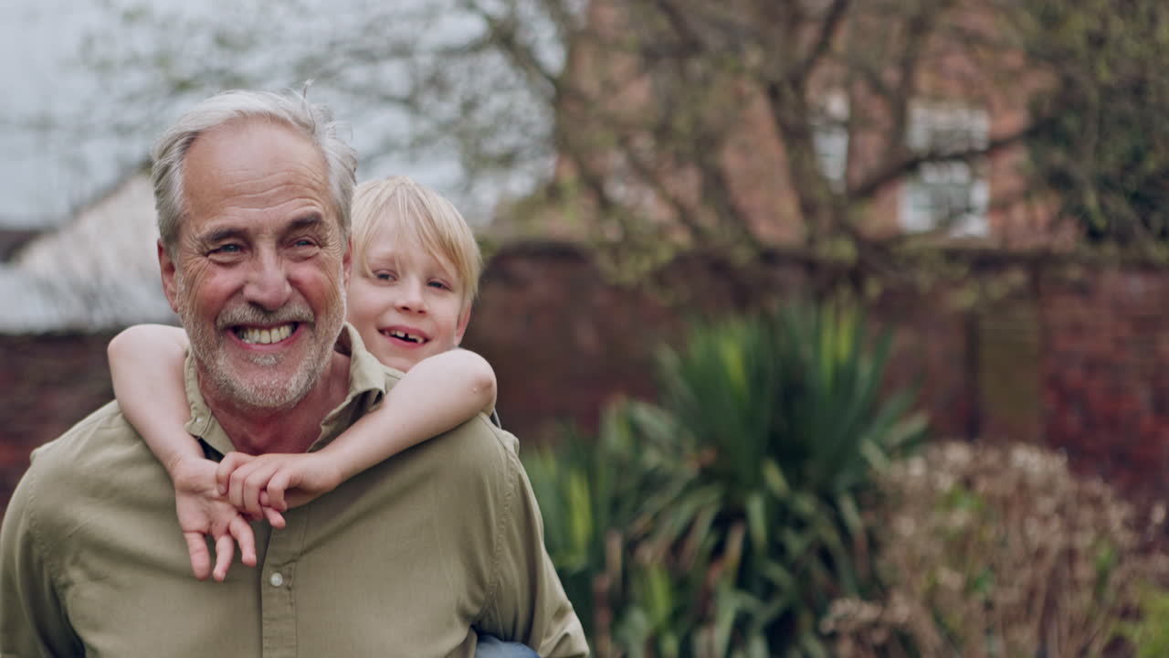 Nonno che porta il nipote in spalla in giardino