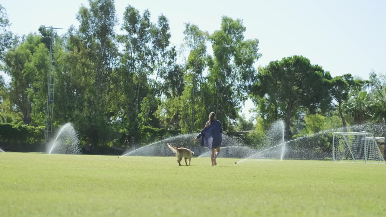 hermosa chica jugando con su feliz perro golden retriever al aire libre en el parque de verano