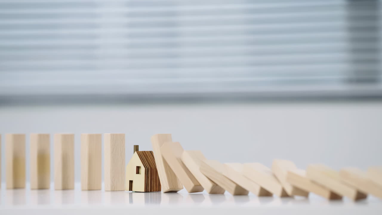 Sicurezza assicurazione casa, pianificazione investimenti immobiliari e attività di protezione della proprietà, valutazione del rischio, ricostruzione edilizia, recupero da disastri, blocco di legno che cade su una casa.